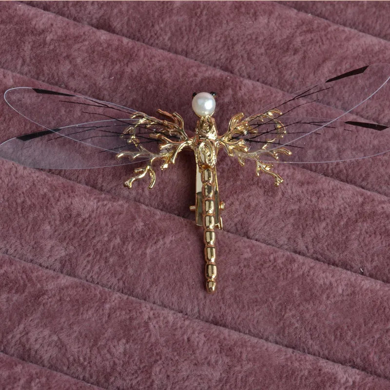 Golden dragonfly-shaped metal alloy headdress with a side clip for hair.