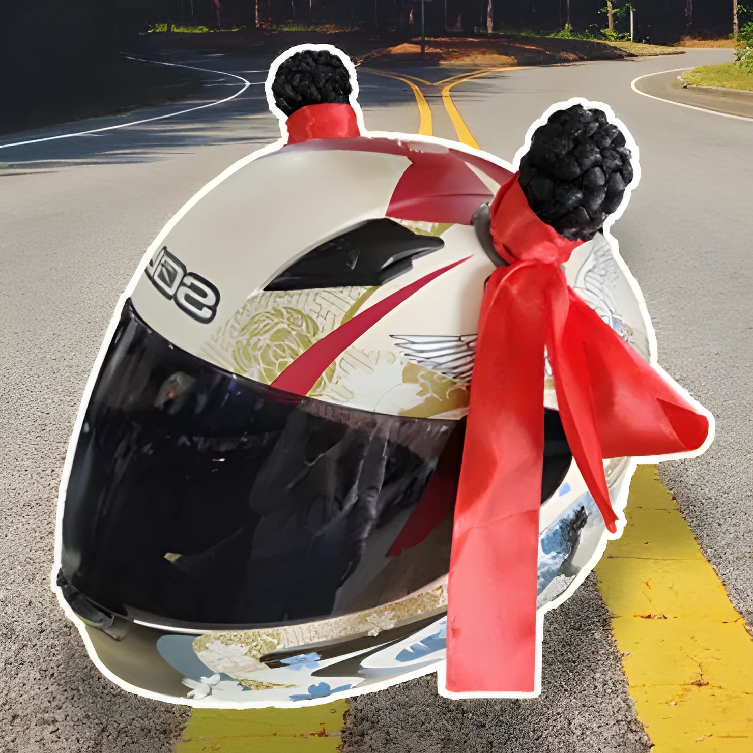 Pair of decorative braided balls for helmet customisation next to a tube of adhesive