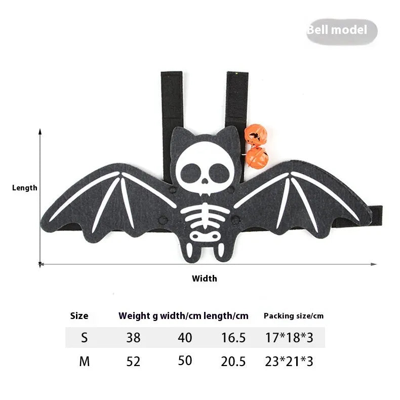 Black cat wearing an orange felt batwing Halloween costume with bell attachment.