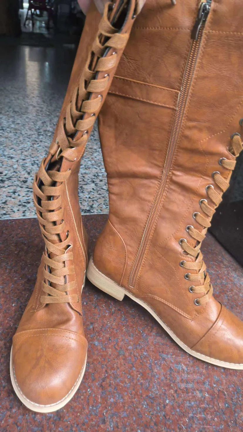 Women's black knight ankle boots with a cross strap detail on a white background.