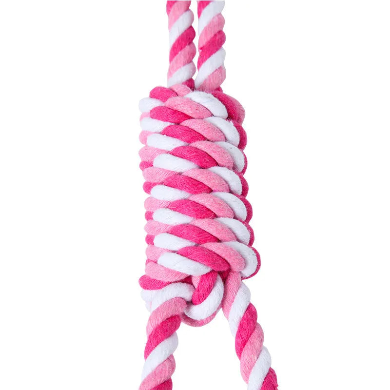 Braided red and white cotton rope dog tug toy for large breeds on a wooden floor.
