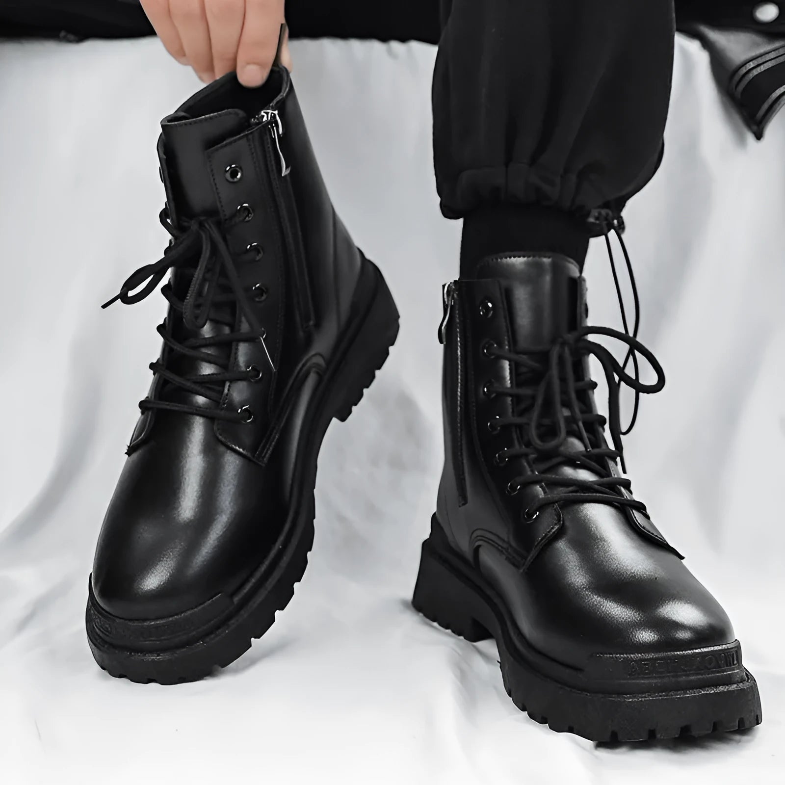 Men's black mid-top Tide British leather boots with a flat rubber sole on a neutral background.