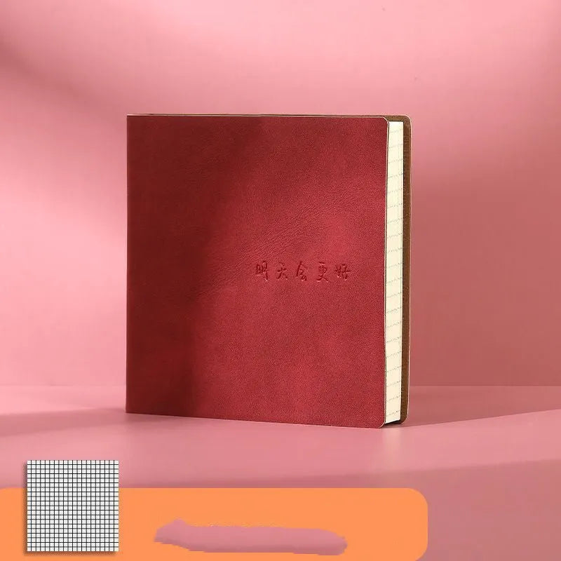Square notebook with textured faux leather cover showing French fold binding and open blank pages