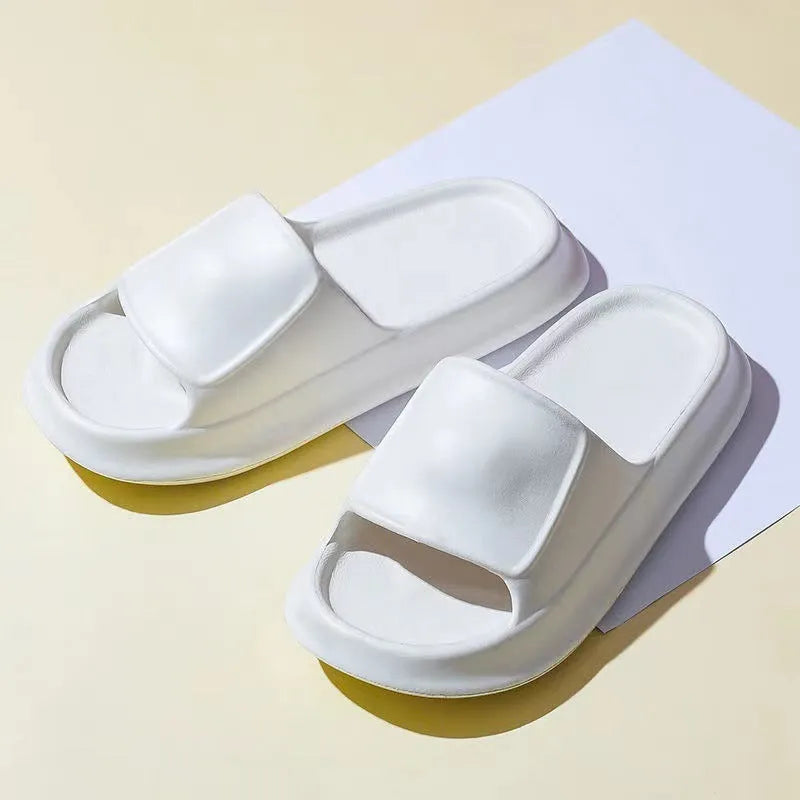 Thick-soled EVA flip-flop slippers in multiple colours on a bathroom floor, showing non-slip sole texture.