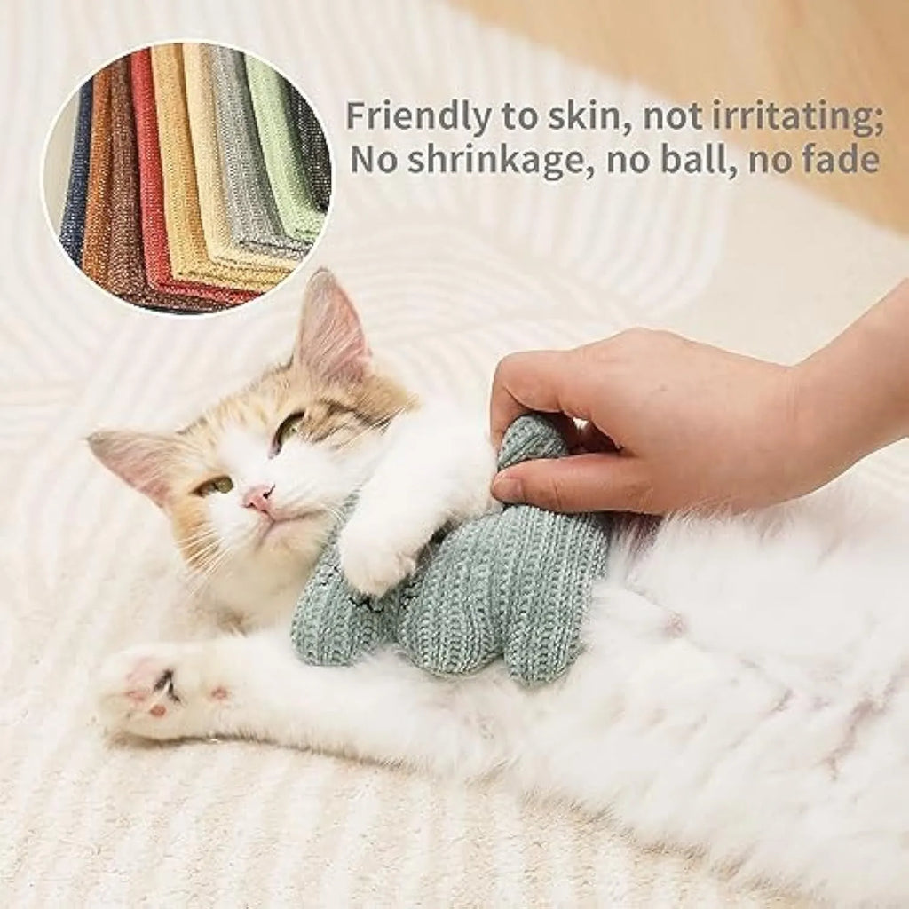 Cyan knitted plush cat toy with bell and catnip filling on a white surface.