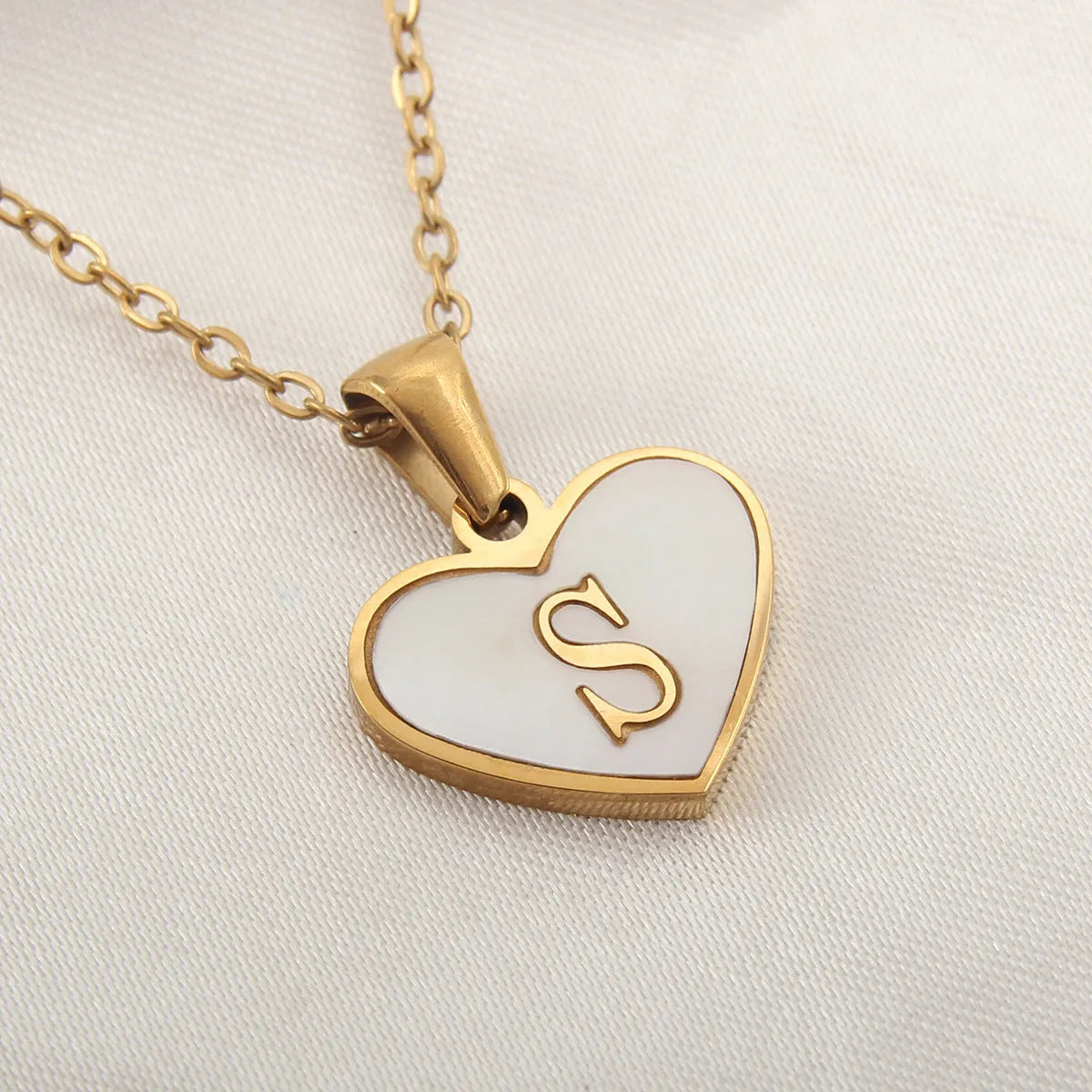 Gold plated heart-shaped white shell pendant personalised initial necklace on a stainless steel chain.