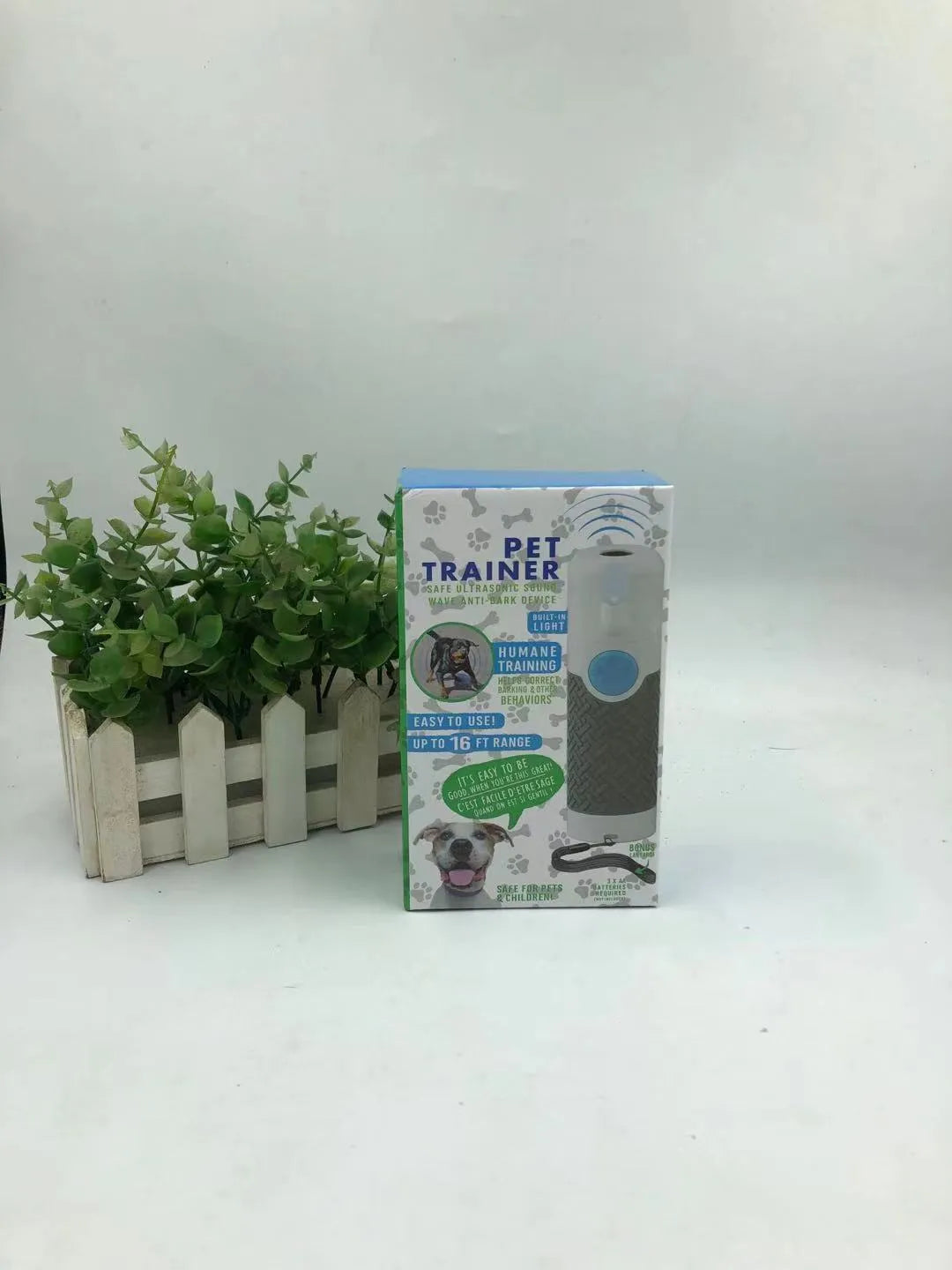 White handheld ultrasonic dog trainer and bark-stop device on a plain background.