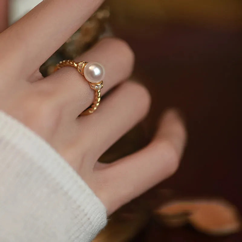 Adjustable antique twist ring with a pearl inlay, shown in gold and silver copper finish.
