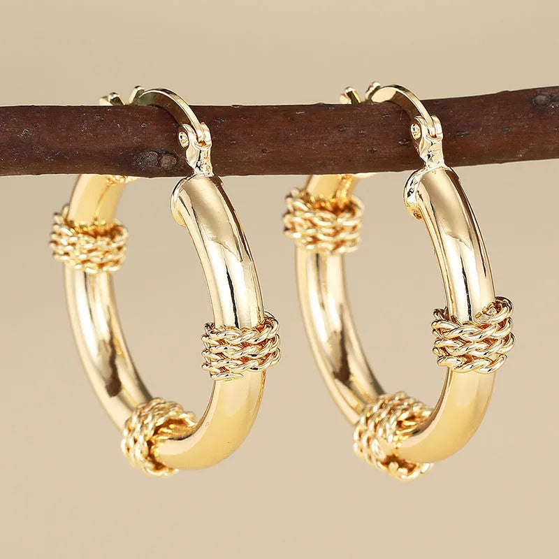 Geometric copper earrings with ring and line design in golden colour on ear