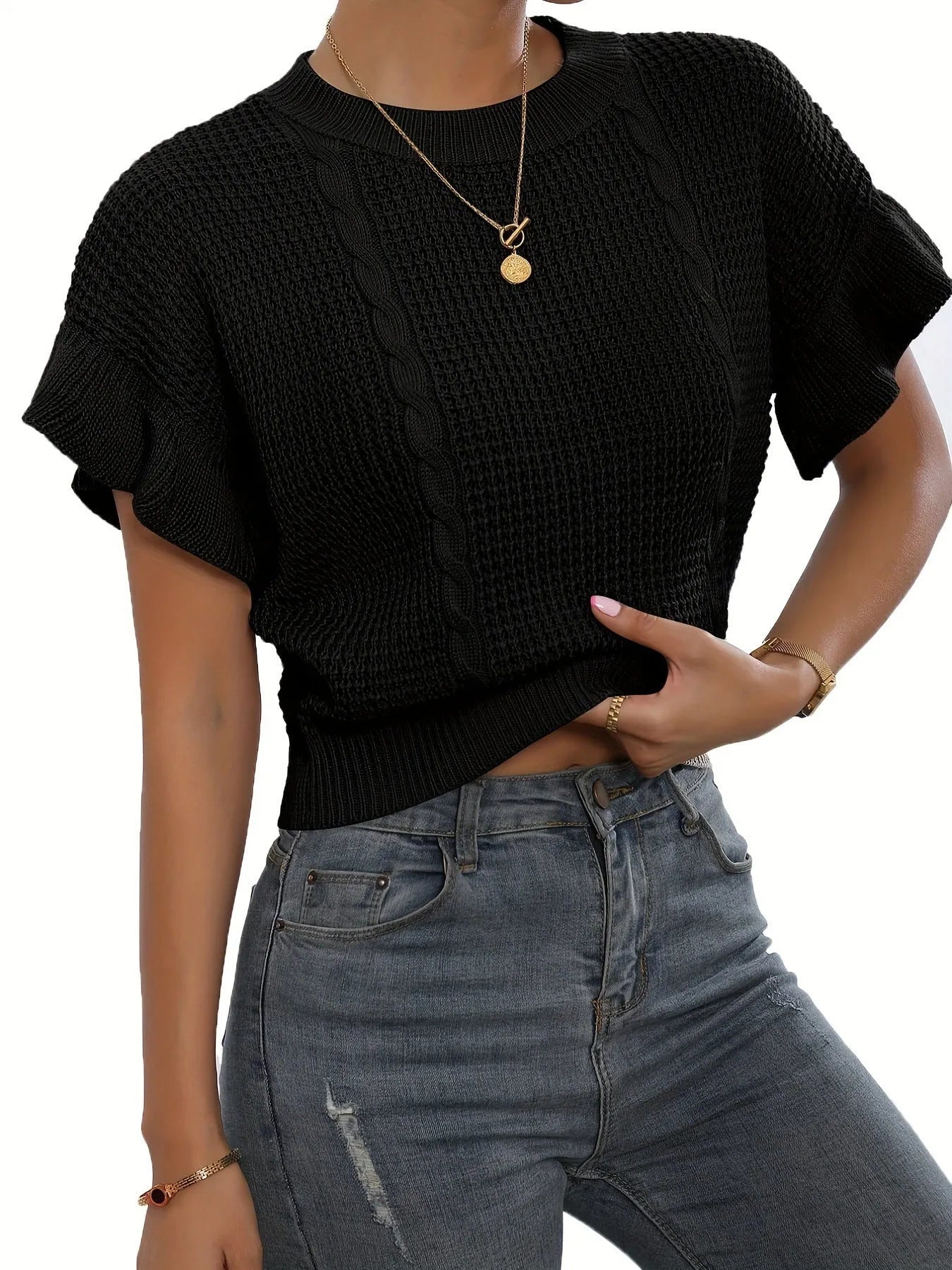 Loose-fitting white knitted pullover sweater with textured ruffled short sleeves on a model.