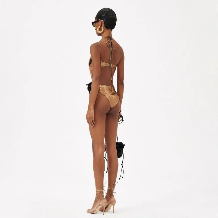 Gold coloured one-piece swimsuit with halter neckline on a model.