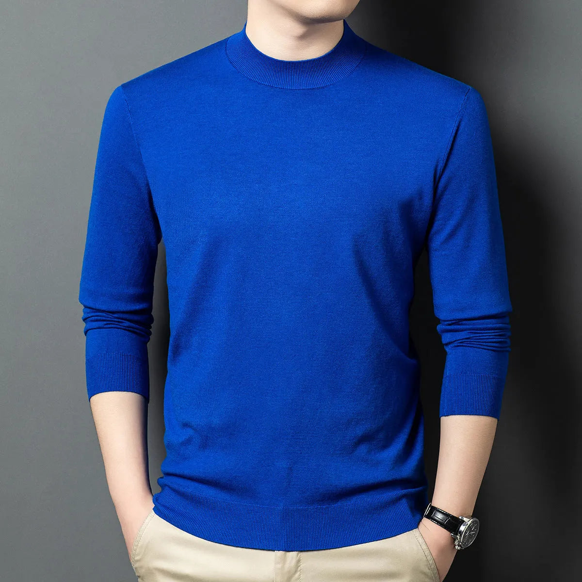 Man wearing a round neck grey wool blend sweater with long sleeves.