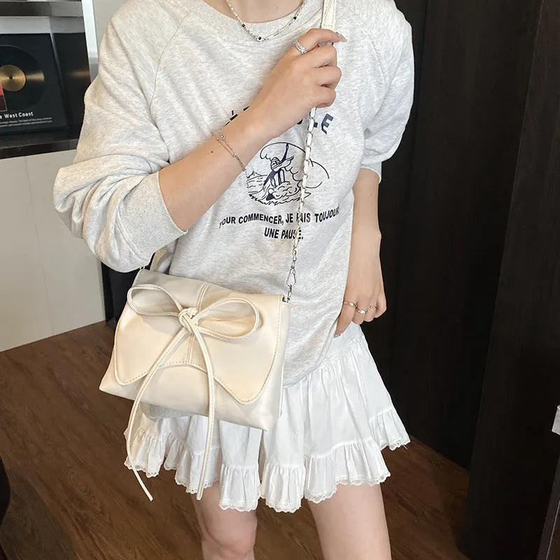 Women's underarm crossbody bag in horizontal square shape with sewing line details and phone pocket
