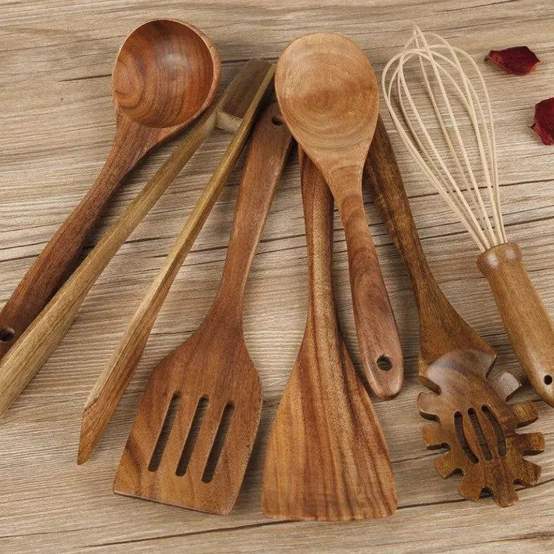 A set of seven wooden cooking utensils including spoons and spatulas on a kitchen counter.
