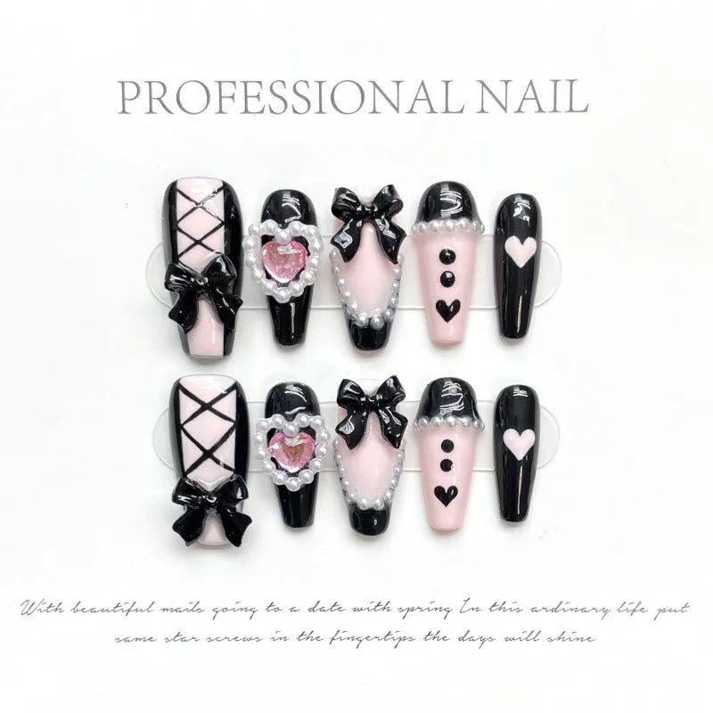 Black and pink heart hand-painted detachable artificial nails with bow design, shown in sizes XS, S, M, L.