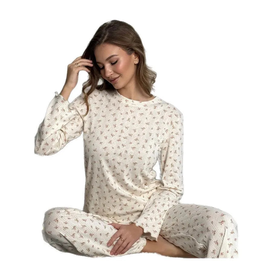 White floral print women's two-piece suit with bell sleeve top and wide leg trousers laid flat.