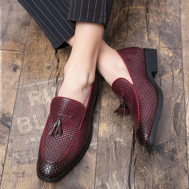 Men's black pointed toe slip-on shoes with a tassel detail on the vamp
