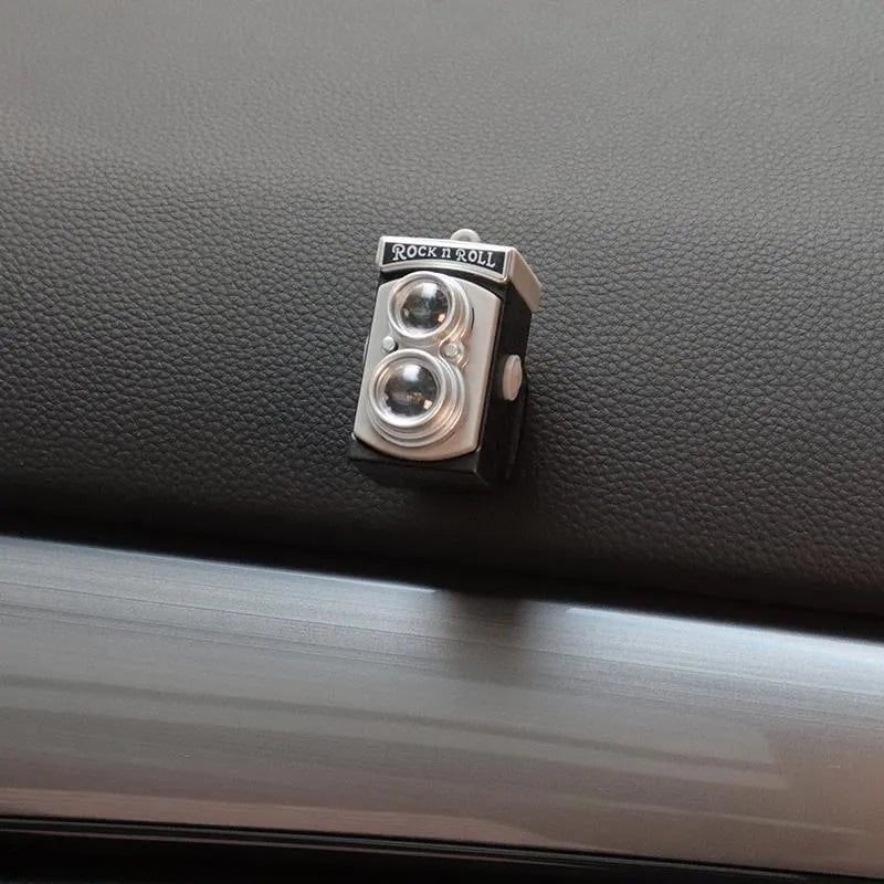 Set of four retro camera dot design plastic adhesive hooks for car dashboard organisation.
