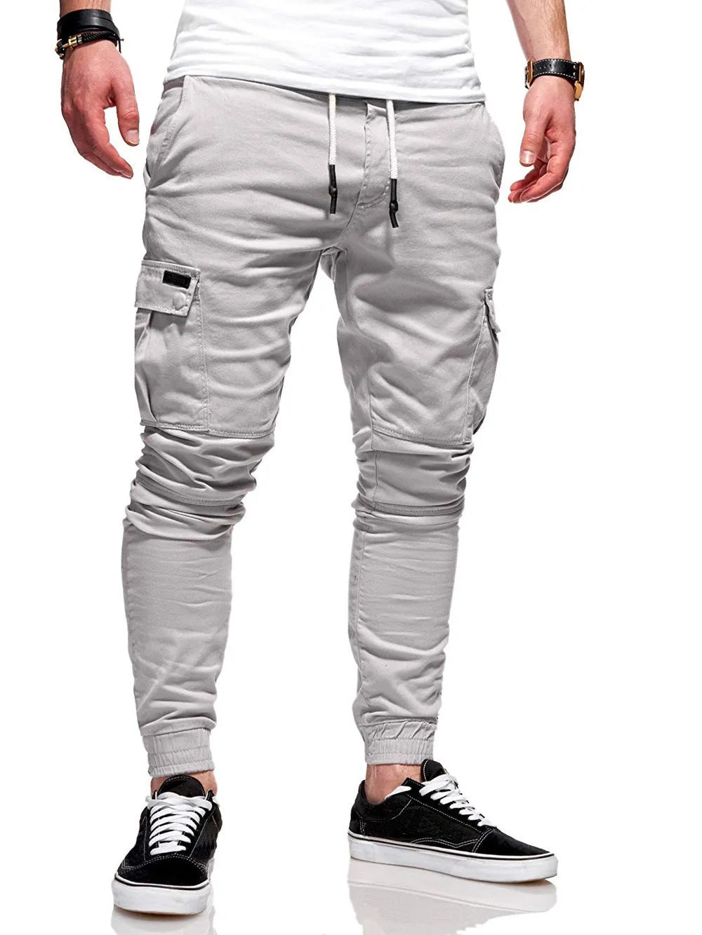 Man wearing loose light blue casual trousers with patch pockets and an elasticated waist.