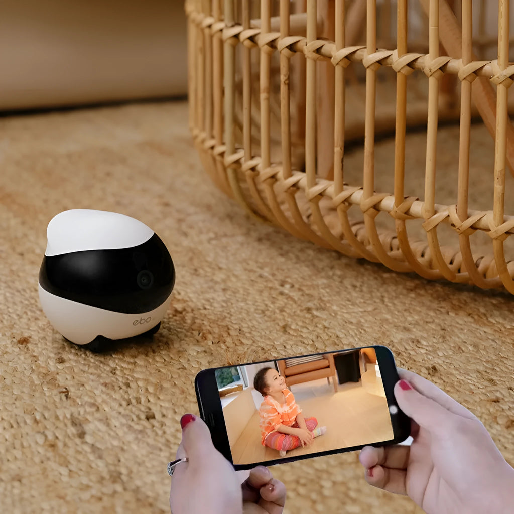 White mobile surveillance robot camera with wheels next to its automatic charging docking station