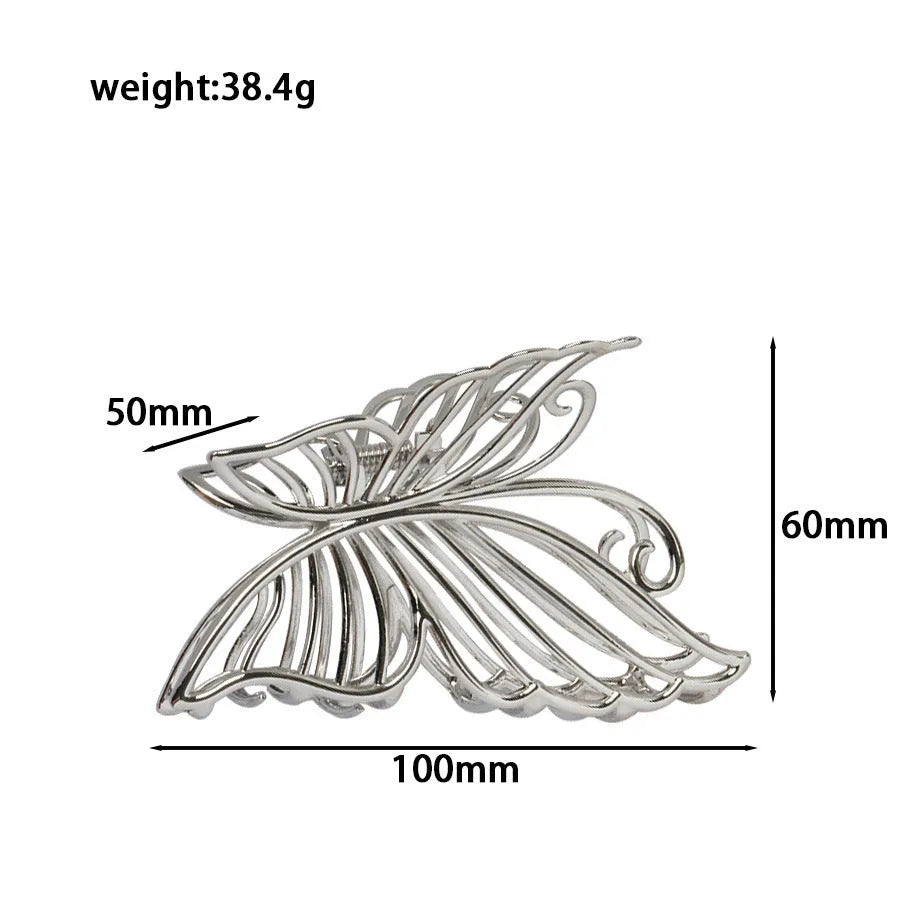Assortment of silver metal hair claw barrettes with various designs including bows, pearls, and geometric shapes.