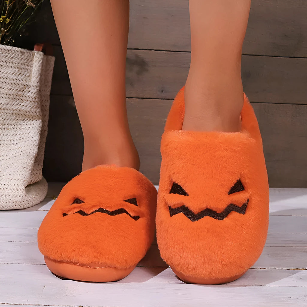 Orange women's pumpkin-themed plush slippers with a coral velvet upper and a flat non-slip sole.