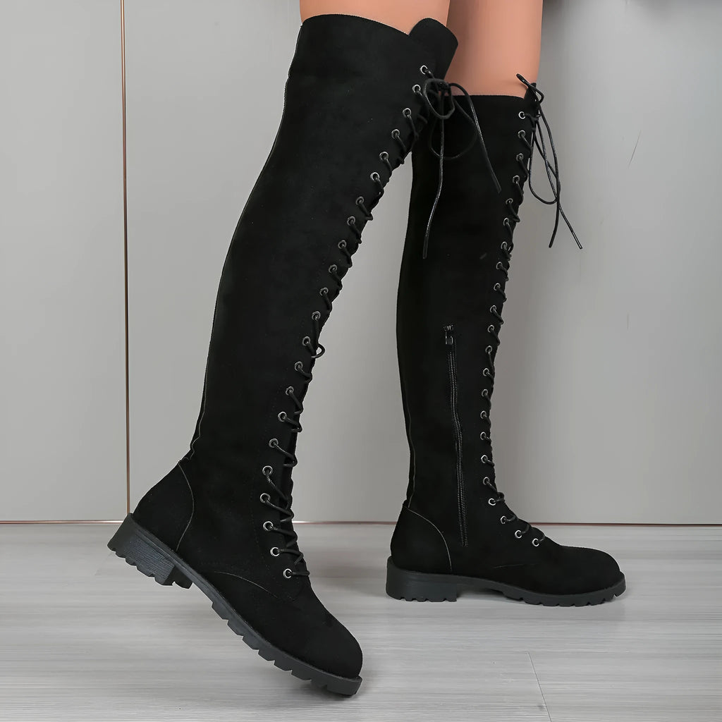 Black lace-up over-the-knee boots with a flat heel and round toe on a white background.