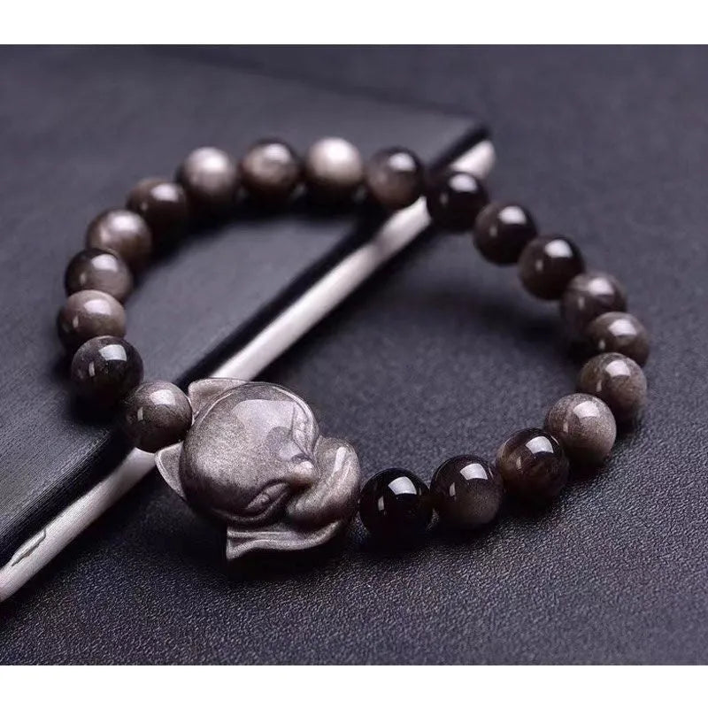 Adjustable obsidian bracelet with a single polished 8mm bead carved with a fox design.