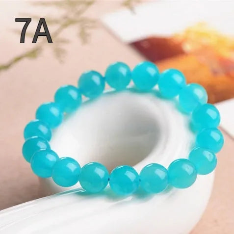Polished natural Amazonite scattered beads in blue-green ice colours on a white background, showing different sizes from 6mm to 13mm.