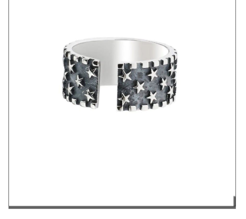 Close-up of a sterling silver ring with a geometric five-pointed star design on an adjustable band.