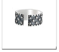 Close-up of a sterling silver ring with a geometric five-pointed star design on an adjustable band.