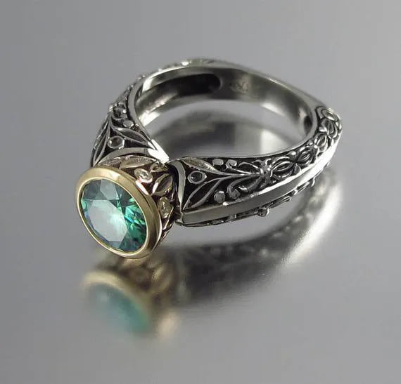 Gold and silver vintage flower-shaped ring with a central green gemstone, shown in a size selection.
