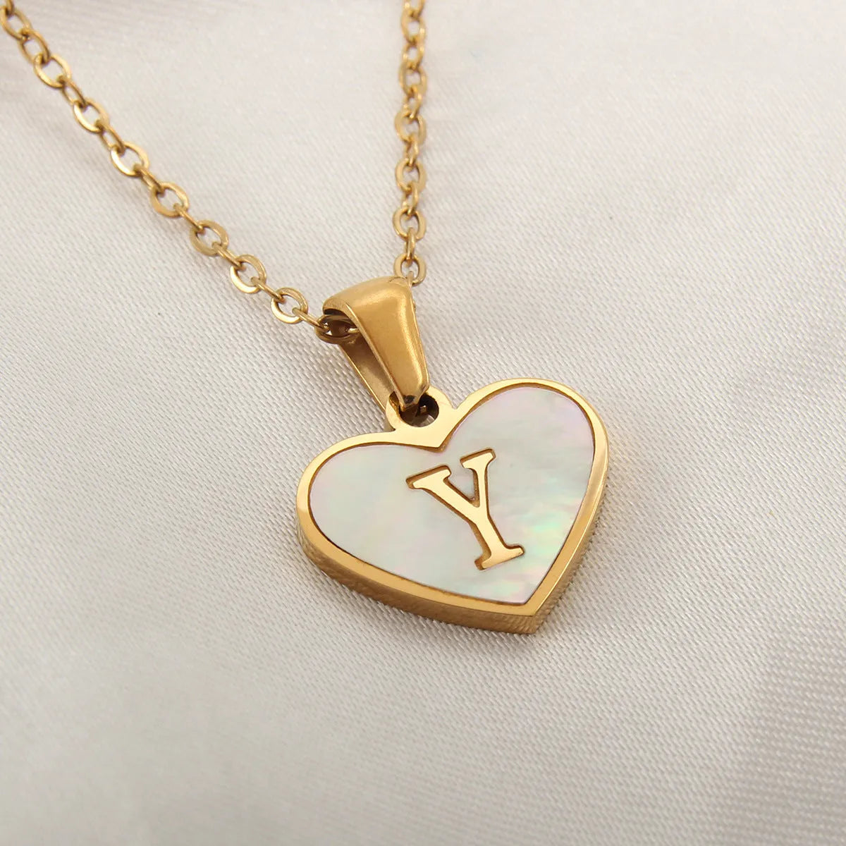 Gold plated heart-shaped white shell pendant personalised initial necklace on a stainless steel chain.