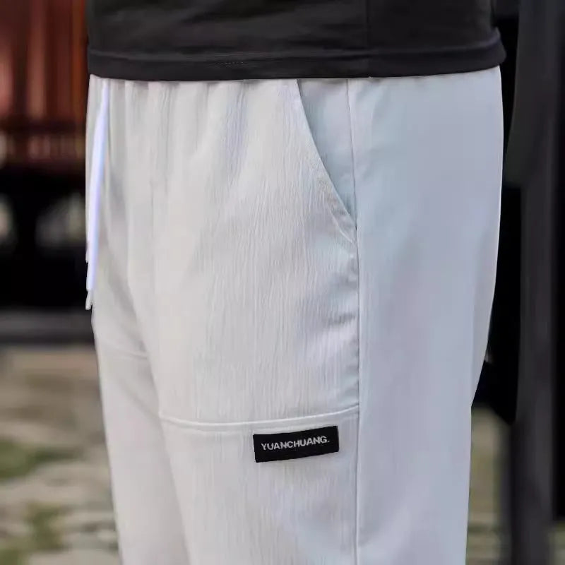 Men's lightweight polyester casual trousers in light grey colour shown flat