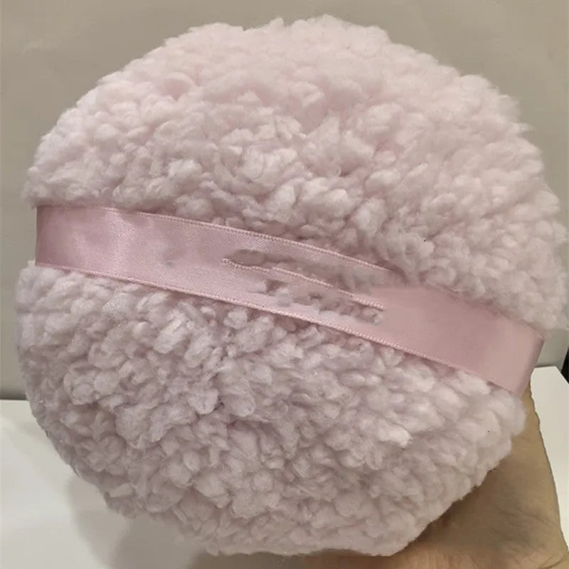 Oversized rectangular plush powder puff for makeup application in pink, white, or skin colour.