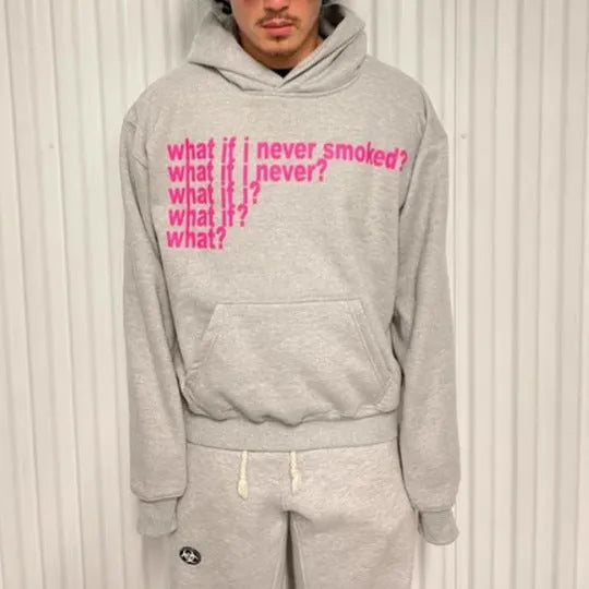 Man wearing a black heavyweight hooded sweater with a large white letter print design on the front.