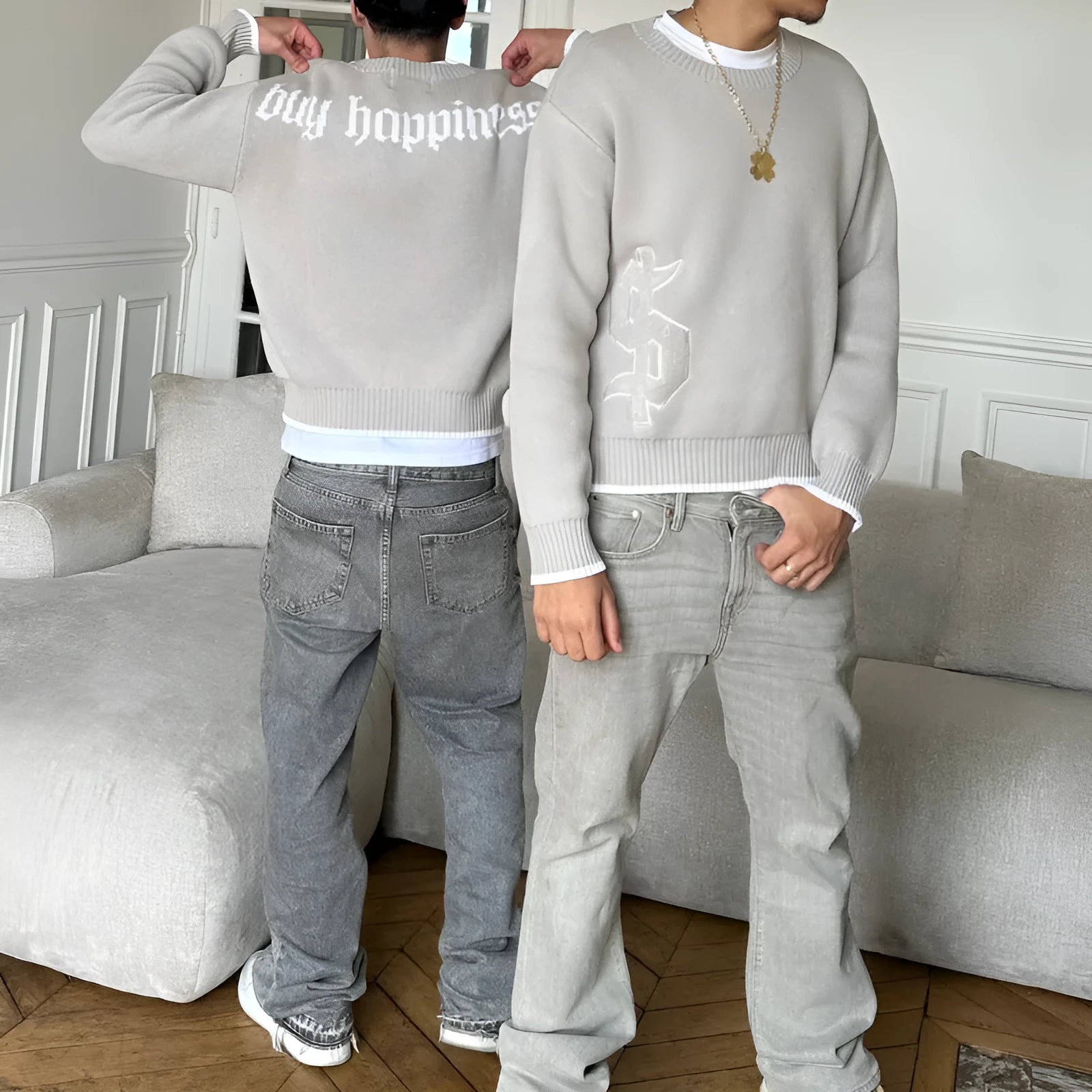 Grey loose-fitting jacquard knit pullover coat with long sleeves on a hanger.