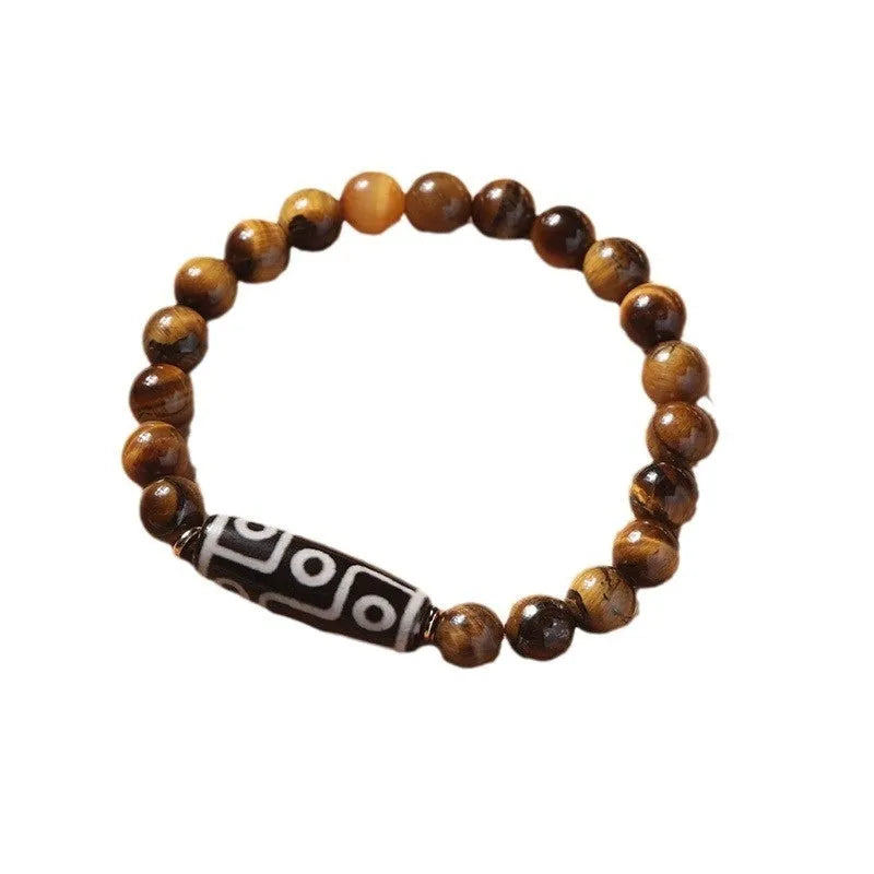 Close-up of a single-circle beaded Buddha rosary bracelet with tigereye dzi patterns on brown beads.