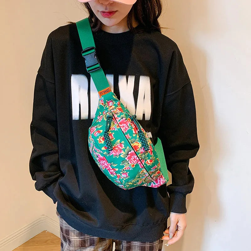 Women's black waist bag with large red flower design and western stitching details.