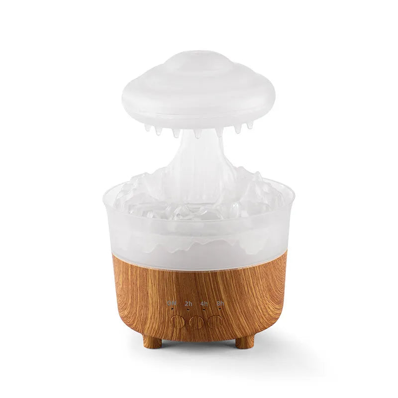 Wood grain green rain cloud shaped humidifier diffuser with coloured LED light on a table.