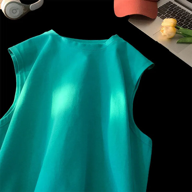 Men's solid colour loose fit cotton tank top on a hanger, showing straight hem and sleeveless design.