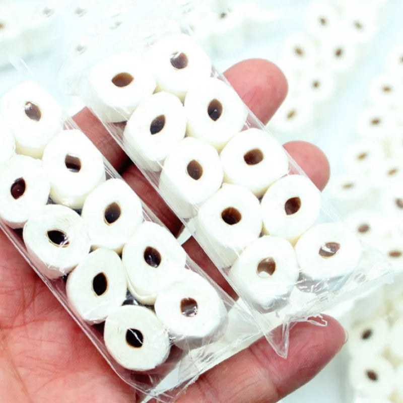 Small-scale simulated toilet paper roll model made of paper, shown next to a ruler for scale.