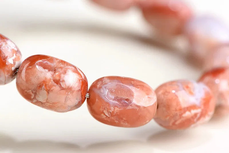 Natural cherry agate bracelet with barrel-shaped beads showing Ruyi geometric design