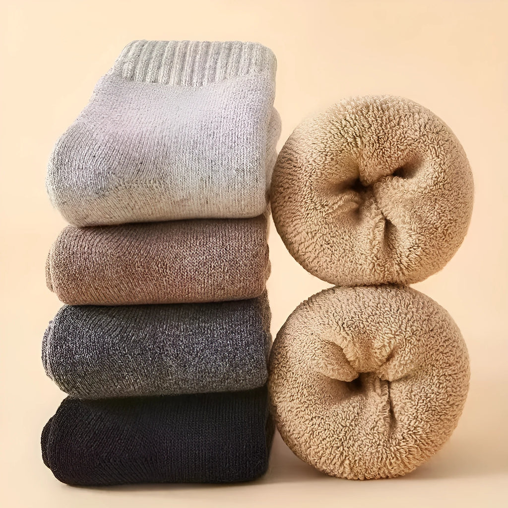 A pair of solid-colour thick wool socks with a winter midsole, shown in a choice of black, khaki, light grey, or dark grey.