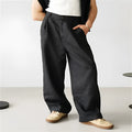 Man wearing loose grey linen blend high-waist pleated jogger pants