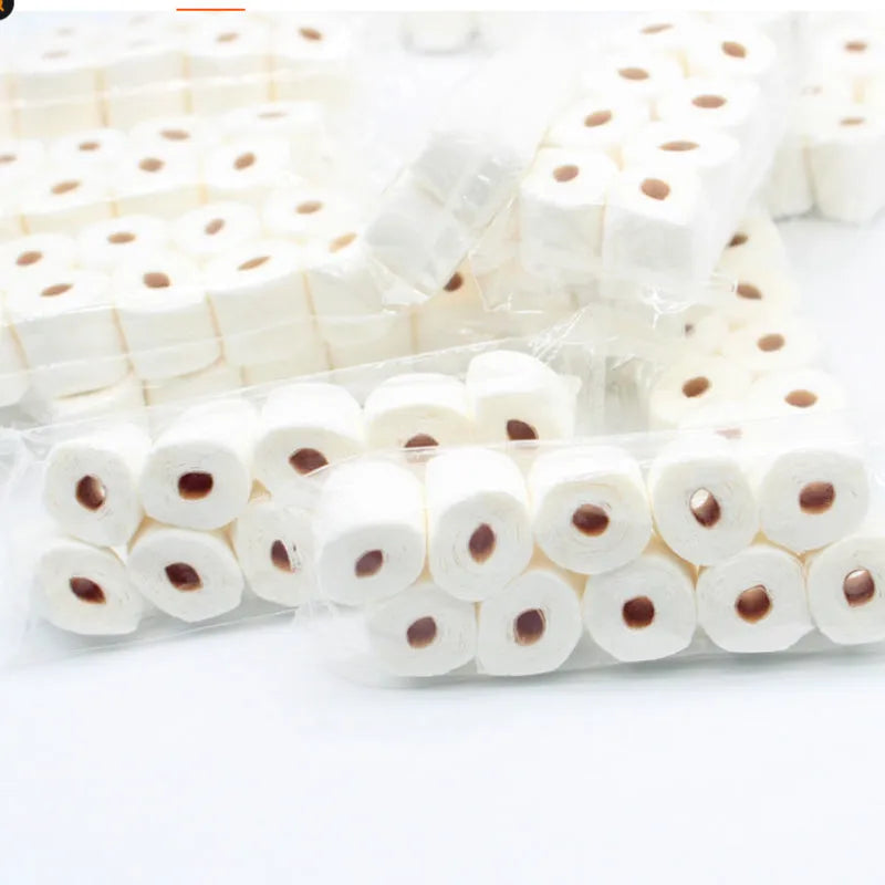 Small-scale simulated toilet paper roll model made of paper, shown next to a ruler for scale.
