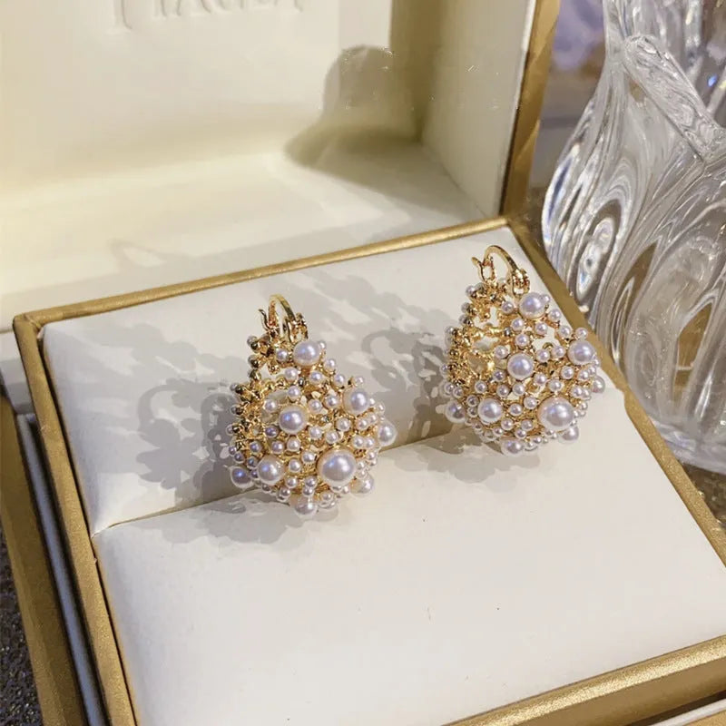 Gold-coloured copper flower basket earrings with small bead and pearl inlay detail.