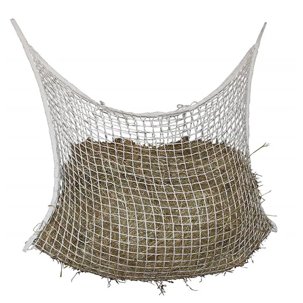 Black woven grid horse feeding bag hanging, filled with hay, for cattle or sheep.