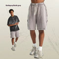 Men's loose black batik washed cotton shorts with patch craft design on a neutral background.