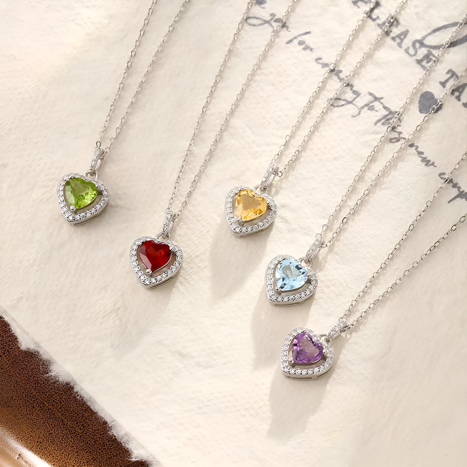 Heart-shaped sterling silver pendant necklace with a natural gemstone on an adjustable chain.